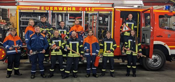 Die Teilnehmenden des Moduls 2 vor der Beifahrerseite eines Löschgruppenfahrzeugs.